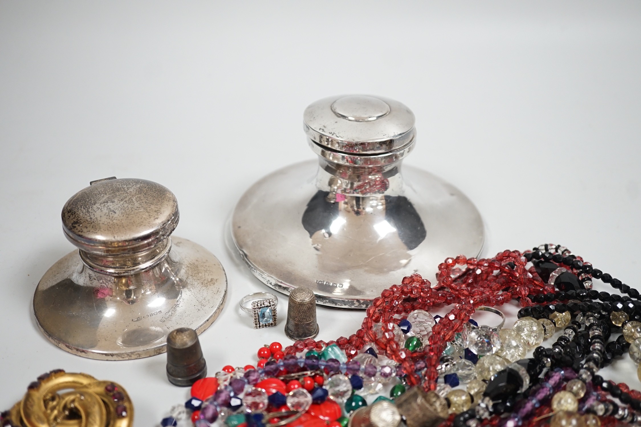 A George V silver mounted capstan inkwell, diameter 13.9cm, a later smaller inkwell and assorted jewellery including a Victorian pinchbeck scroll brooch and costume.